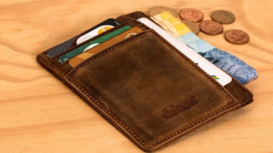 Person comparing different wallet options while shopping, representing affordable accessory choices