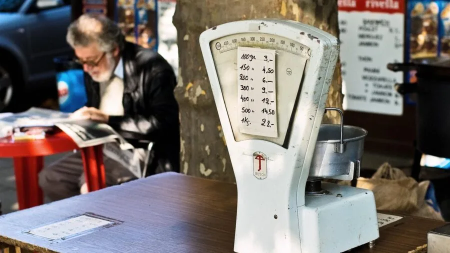 Person comparing microwave specifications while shopping in modern kitchen showroom