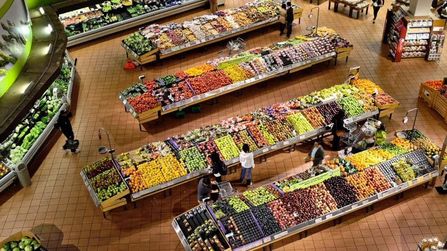 Person comparing prices while shopping for household items in a grocery store