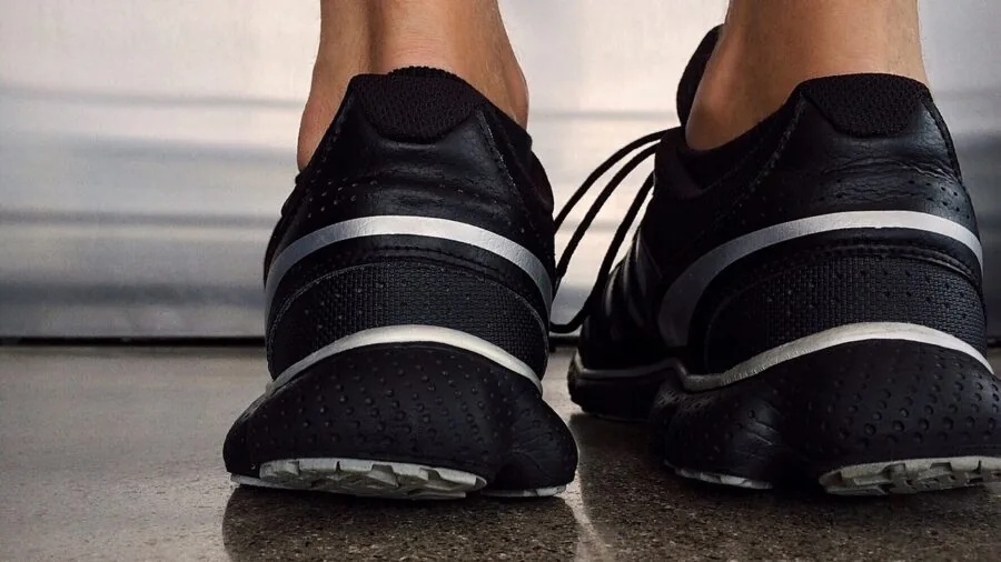 Person comparing running shoe options while planning fitness budget and purchase decision