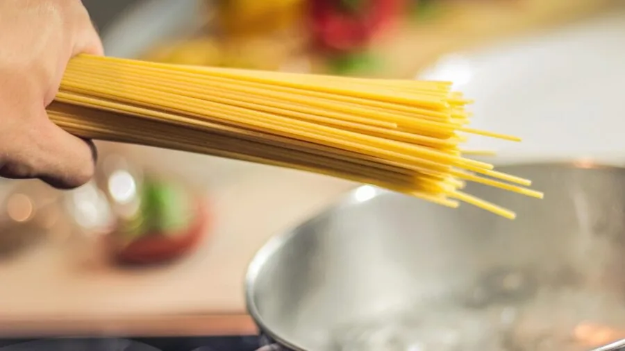 Person cooking in kitchen, holding utensil with comfortable grip during meal preparation