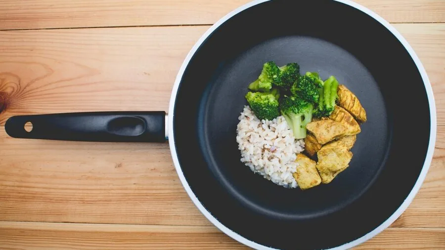 Person cooking with spatula in nonstick pan on stovetop