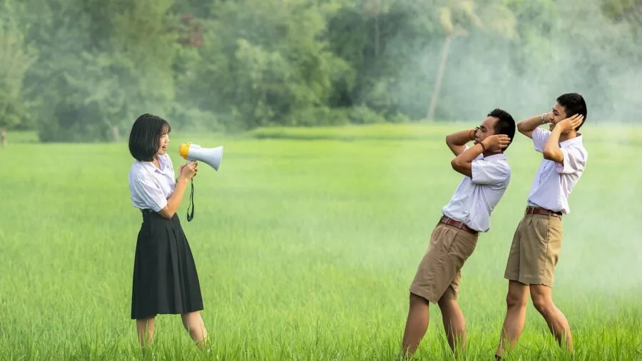 Person covering ears in reaction to loud uncomfortable sound in home environment
