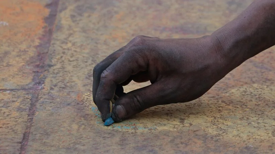 Person creating colorful artwork with markers on paper, demonstrating ink application and blending techniques