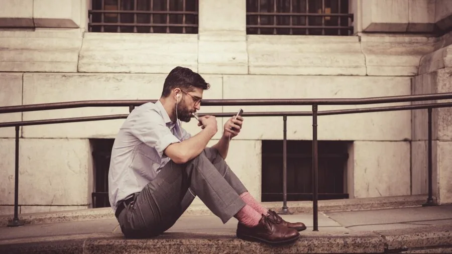 Person deciding between phone options while sitting in car, representing choice between device compatibility