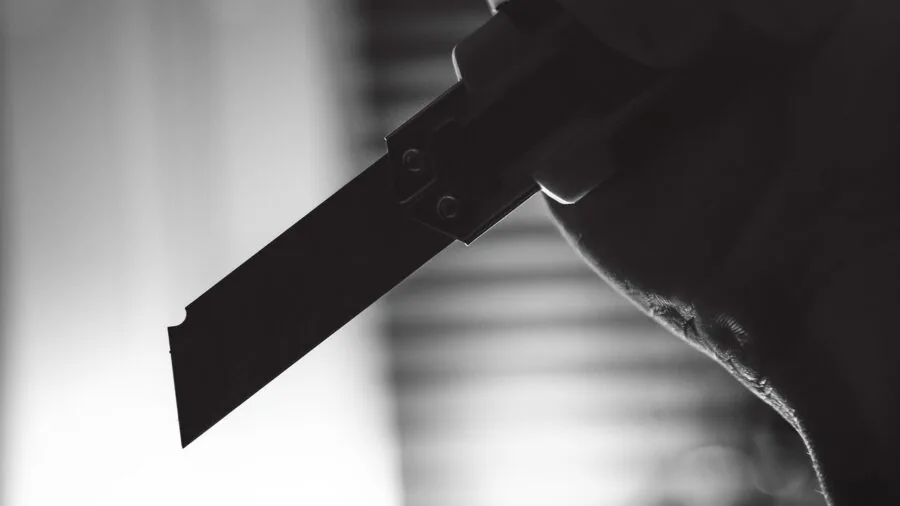 Person demonstrating blade deployment on utility knife during home renovation project