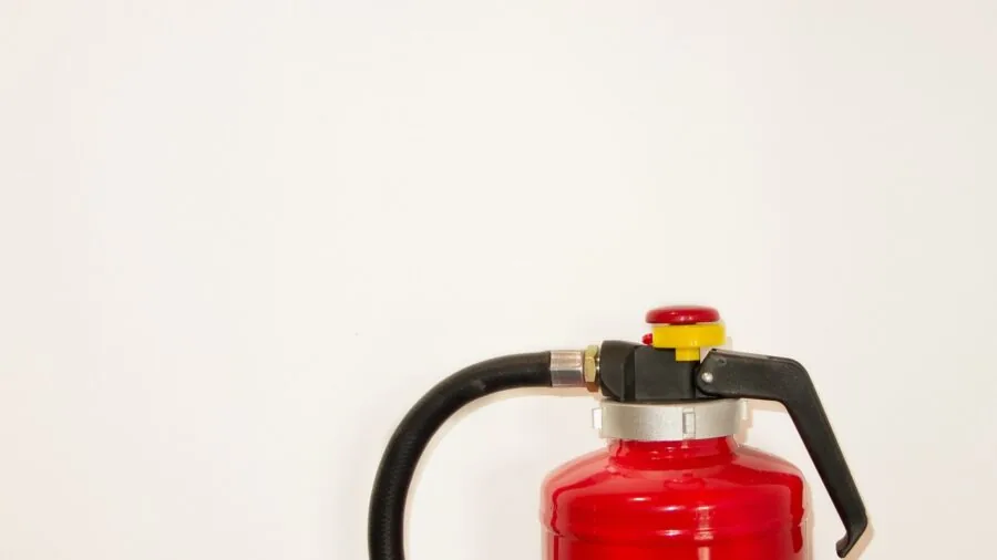 Person demonstrating fire extinguisher use during home safety training or emergency response situation