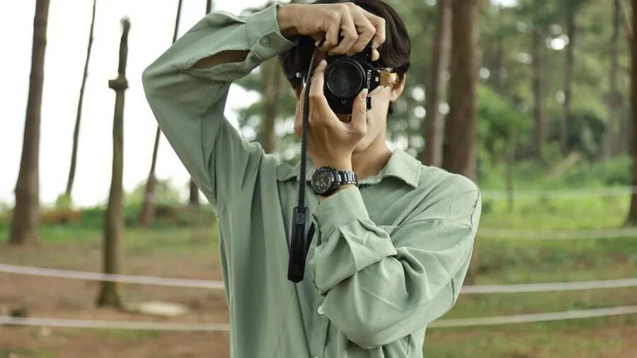 Person demonstrating proper ergonomic grip while holding a yard maintenance tool outdoors