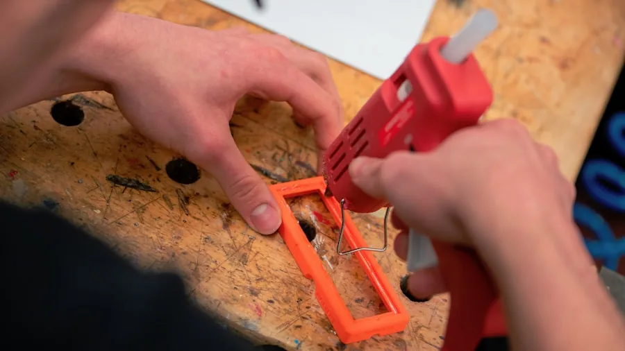Person demonstrating proper hand positioning while using a hot glue gun with protective precautions
