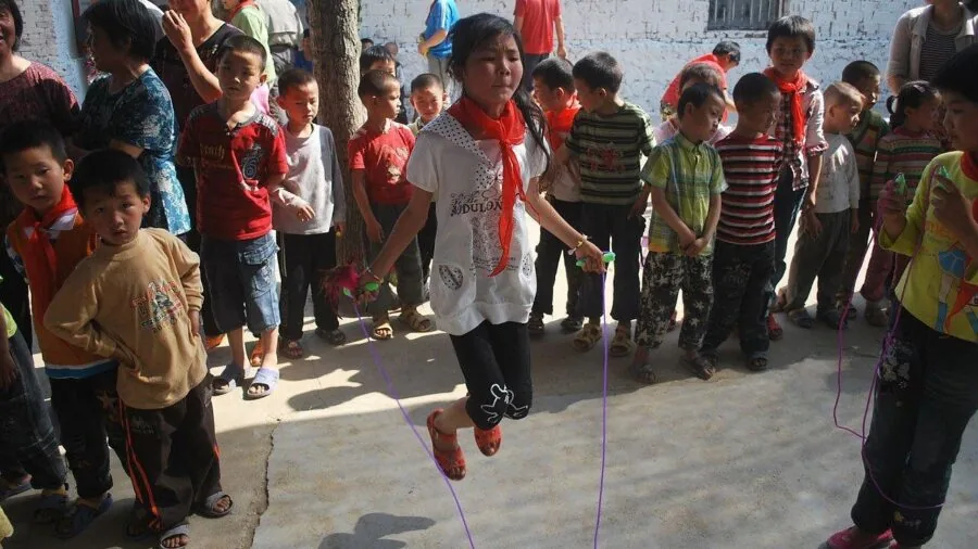 Person doing jump rope exercises outdoors in natural daylight, demonstrating fitness training