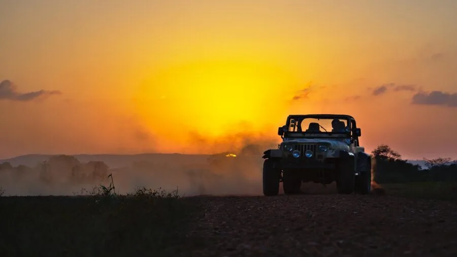 Person driving ATV through rugged terrain in natural landscape during daytime outdoor activity