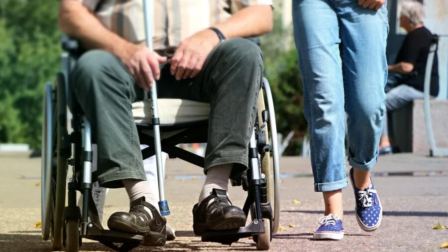 Person easily folding a compact stroller while standing outdoors in natural daylight