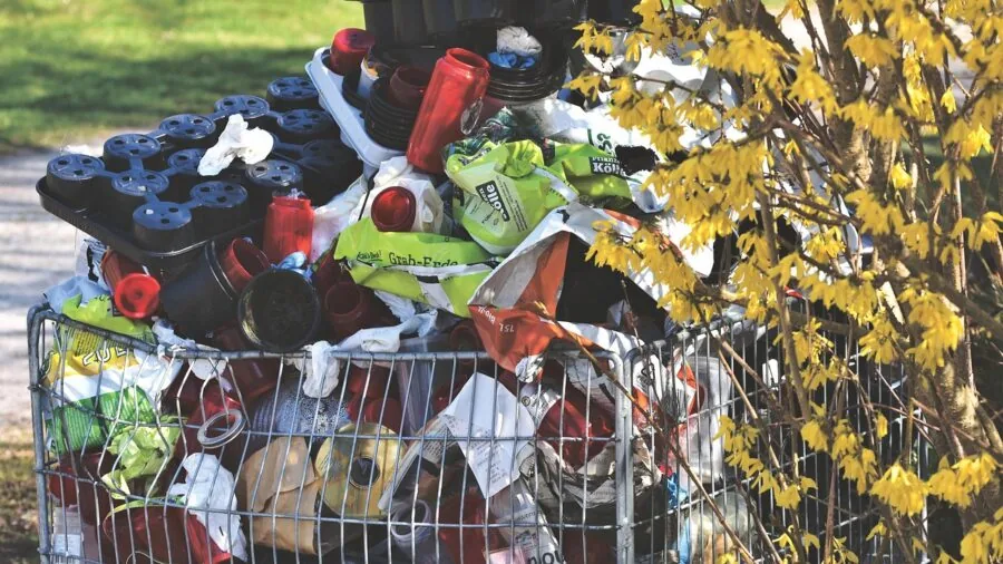 Person emptying a full waste bin in a home office setting