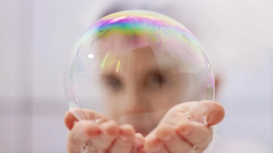 Person enjoying a bubble bath with natural lighting, showing relaxation and skincare wellness