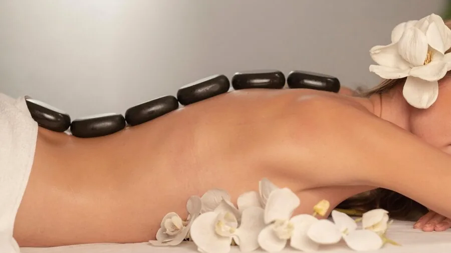 Person enjoying a calming spa foot soak with essential oils and natural aromatherapy elements in a serene setting