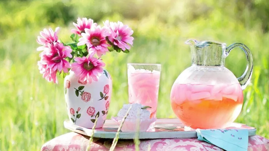 Person enjoying a cold drink while relaxing outdoors in a comfortable lounge chair