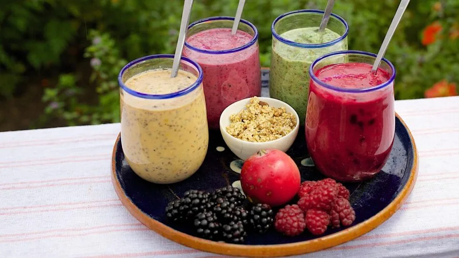Person enjoying a green smoothie drink in a bright kitchen during morning routine