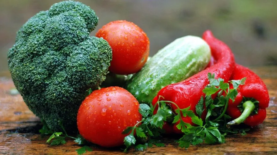 Person enjoying a healthy meal with fresh vegetables and whole grains for digestive wellness