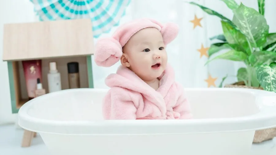 Person enjoying a luxurious bath with bath bombs and products in a modern bathroom setting