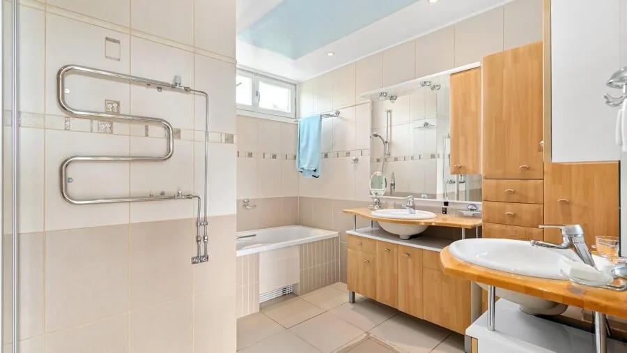 Person enjoying a relaxing bath with pillow support, demonstrating comfort and wellness in a modern bathroom setting