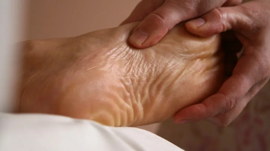 Person enjoying a relaxing foot massage treatment at home, demonstrating therapeutic foot care and wellness