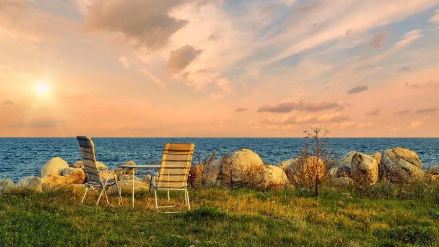 Person enjoying camping chair with drink holder and storage in natural outdoor setting