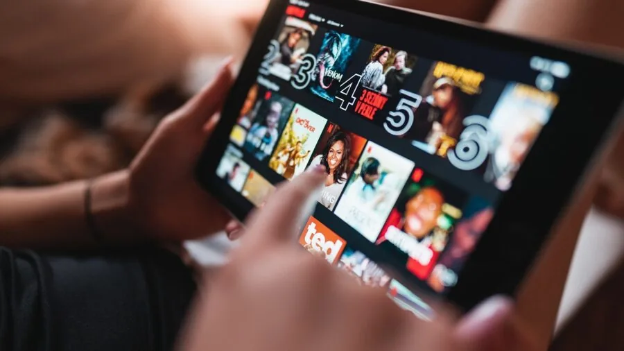Person enjoying high-quality streaming video content on a display device in a home setting