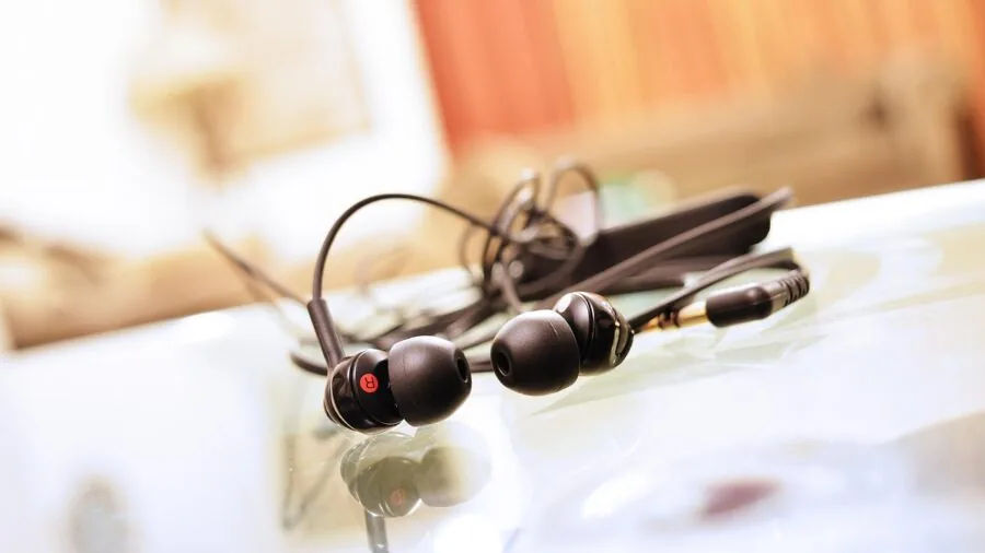 Person enjoying music on mobile device with headphones in casual setting