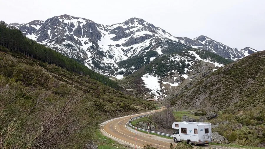 Person enjoying outdoor camping adventure near recreational vehicle in natural landscape setting