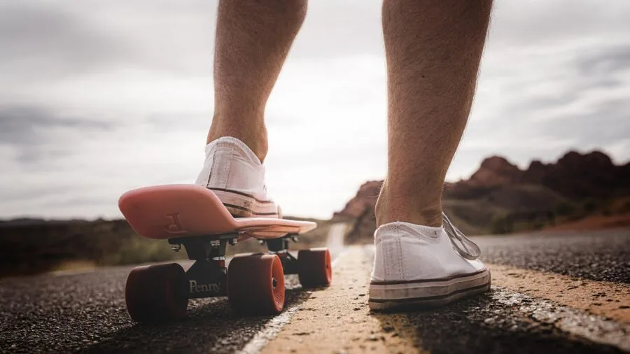 Person enjoying recreational skating outdoors on a sunny day in a park setting
