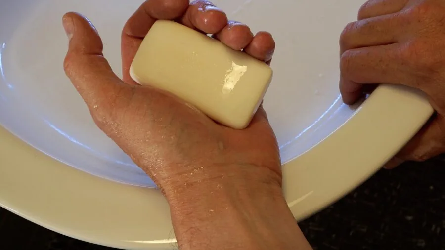 Person enjoying rich soap lather during shower routine in bathroom setting