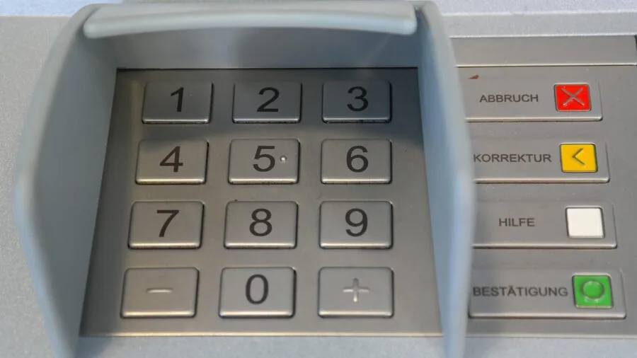 Person entering security code on digital keypad lock for home safe access