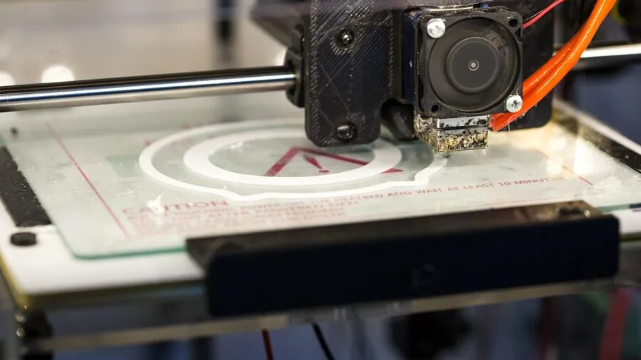 Person examining a large 3D printed object in a maker workshop studio