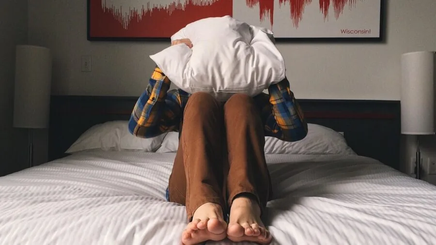 Person examining different fabric textures and bedding materials while making a thoughtful purchasing decision