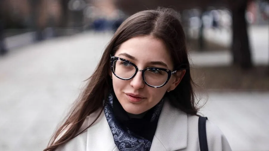 Person examining different frame styles and shapes while selecting reading glasses