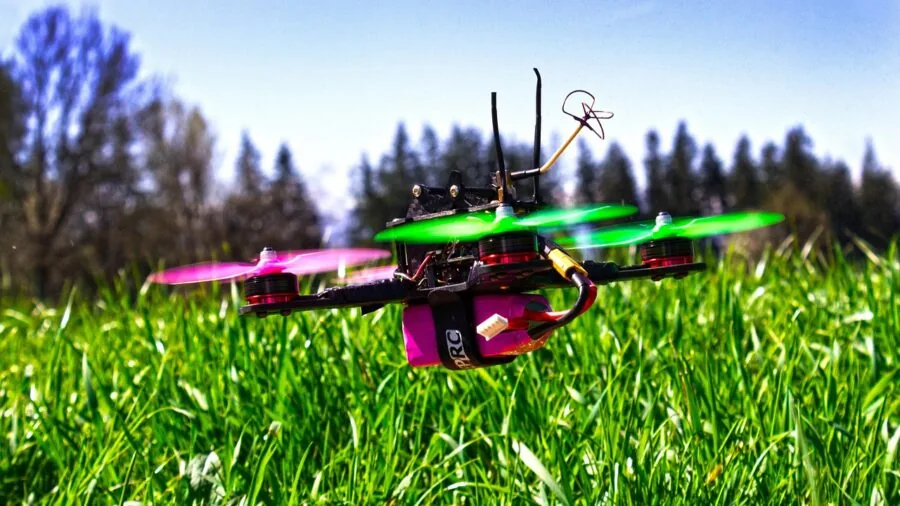 Person examining drone battery specifications outdoors before flight