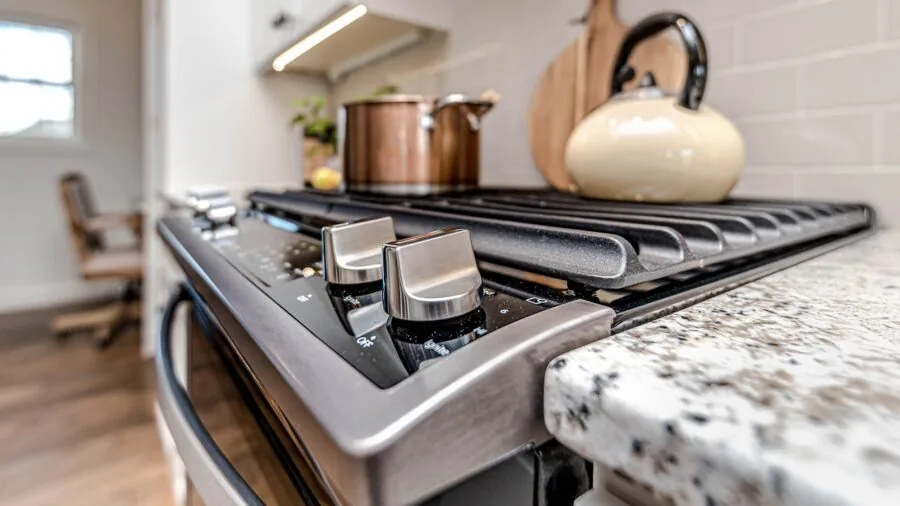 Person examining large oven interior space while planning meal preparation in modern kitchen