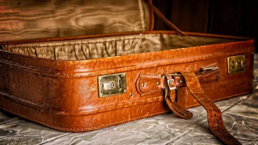 Person examining luggage material and construction to assess quality and durability before purchase