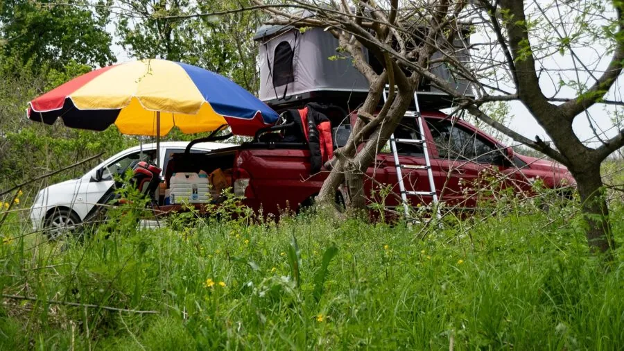 Person examining RV camper tires during trip planning in natural outdoor setting