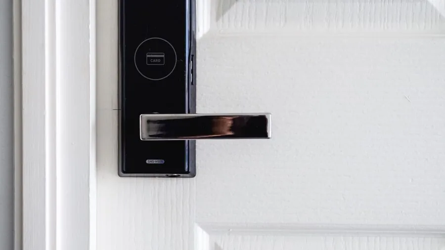 Person examining smart lock on residential door to check battery status and power management