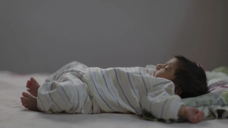 Person examining soft blanket material texture and weight distribution while lying down