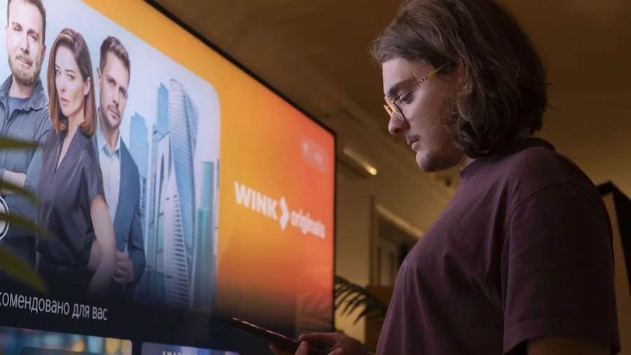 Person examining TV display brightness and picture quality in living room setting