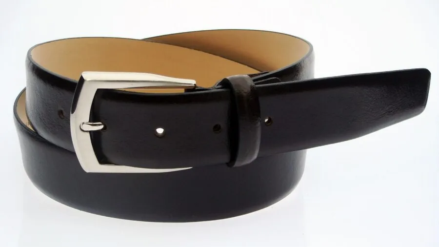 Person fastening a leather lifting belt around waist during weightlifting workout