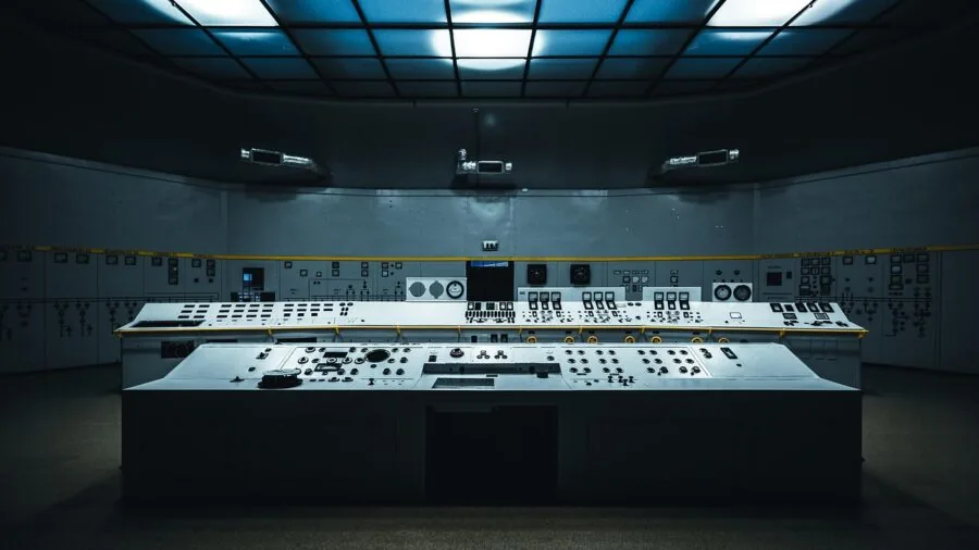 Person fine-tuning audio equipment with focus on control knobs and settings