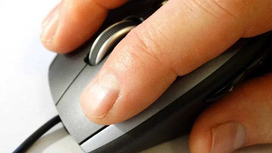Person fine-tuning mouse sensitivity settings on computer for optimal cursor control and precision