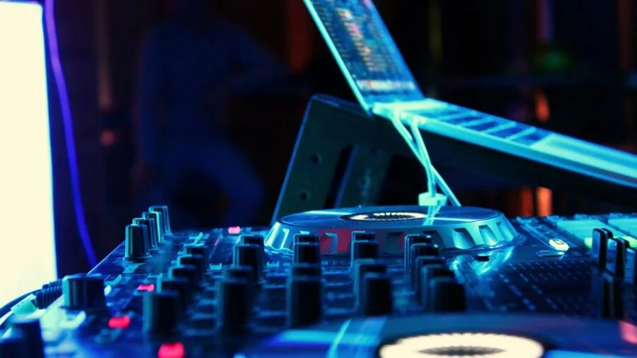 Person fine-tuning sound settings on audio equipment in home studio environment