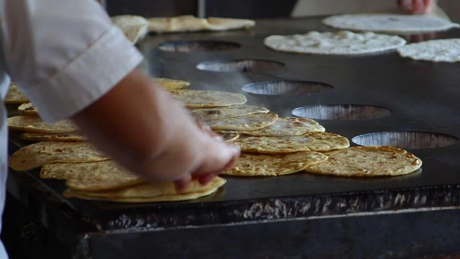 Person flipping pancakes in a skillet on a stovetop during weeknight cooking