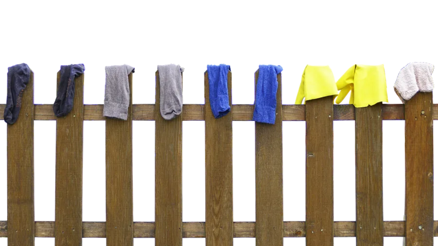 Person folding fresh laundry in a bright, organized laundry room with matching appliances