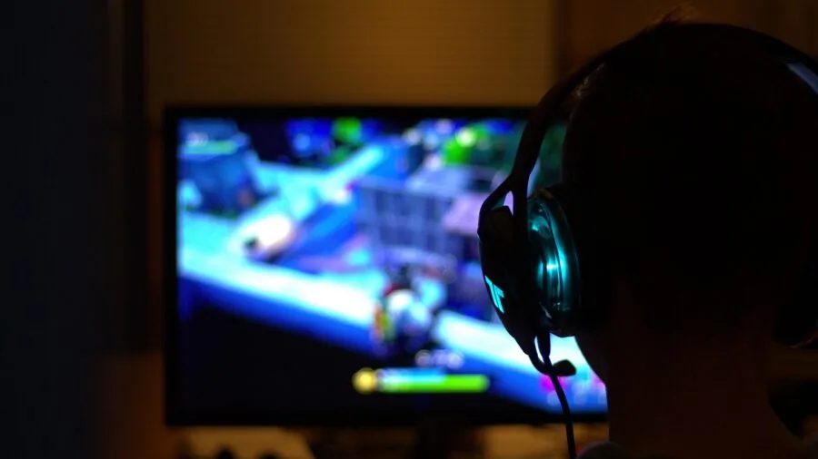 Person gaming at night with controller, focused on extended play session and battery endurance