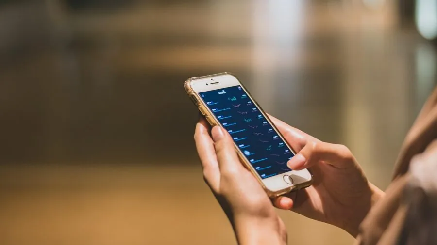 Person gripping smartphone with protective case, showing device size and grip considerations
